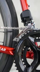 Close-up of a red bicycle's crankset and chain.
